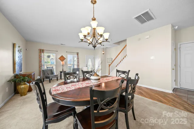a view of a dining room with furniture and chandelier