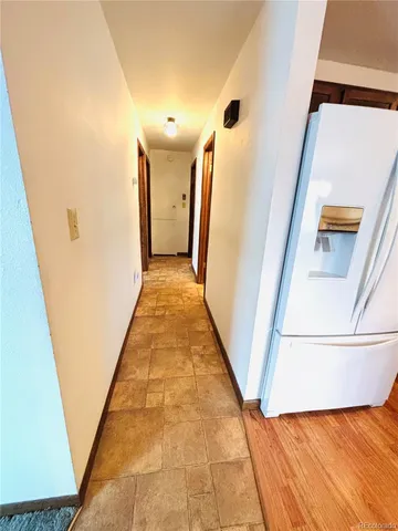 a view of a hallway with wooden floor and stairs