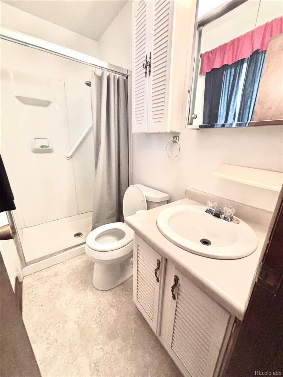 503 Elm Street Fort Morgan, CO 80701 - Photo 16 of 26 a bathroom with a sink a toilet and a mirror