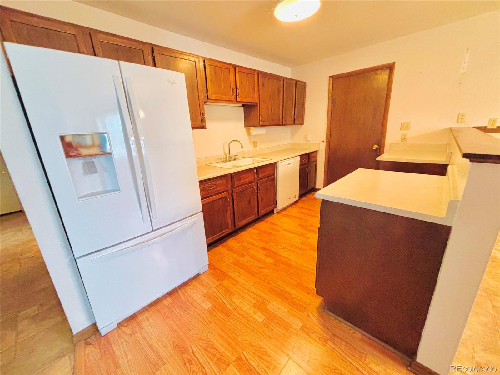 503 Elm Street Fort Morgan, CO 80701 - Photo 5 of 26 a kitchen with a refrigerator and a sink