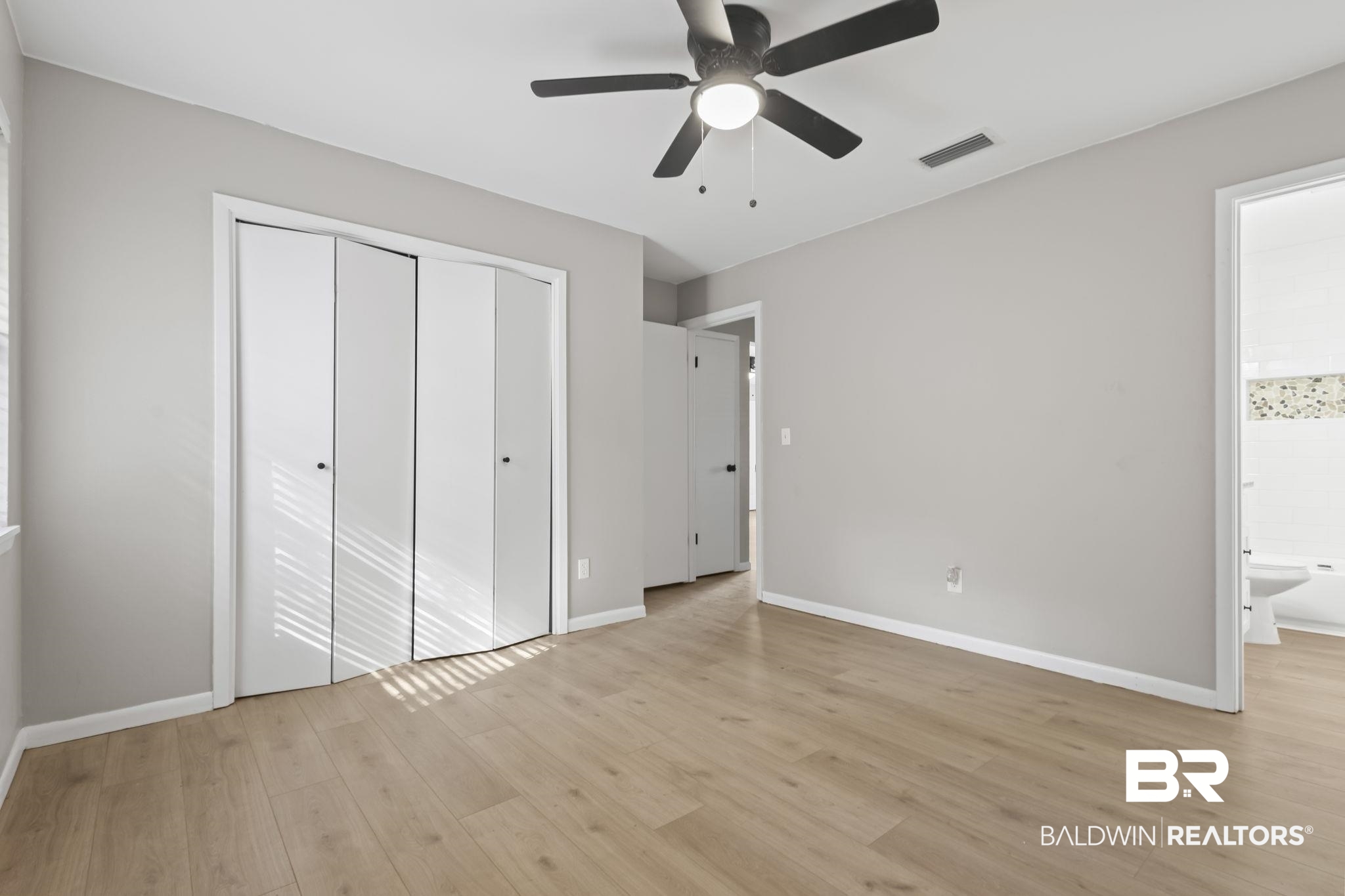 309 West Roosevelt Avenue Foley, AL 36535 - Photo 11 of 60 Unfurnished bedroom with ensuite bath, ceiling fan, a closet, and light hardwood / wood-style floors