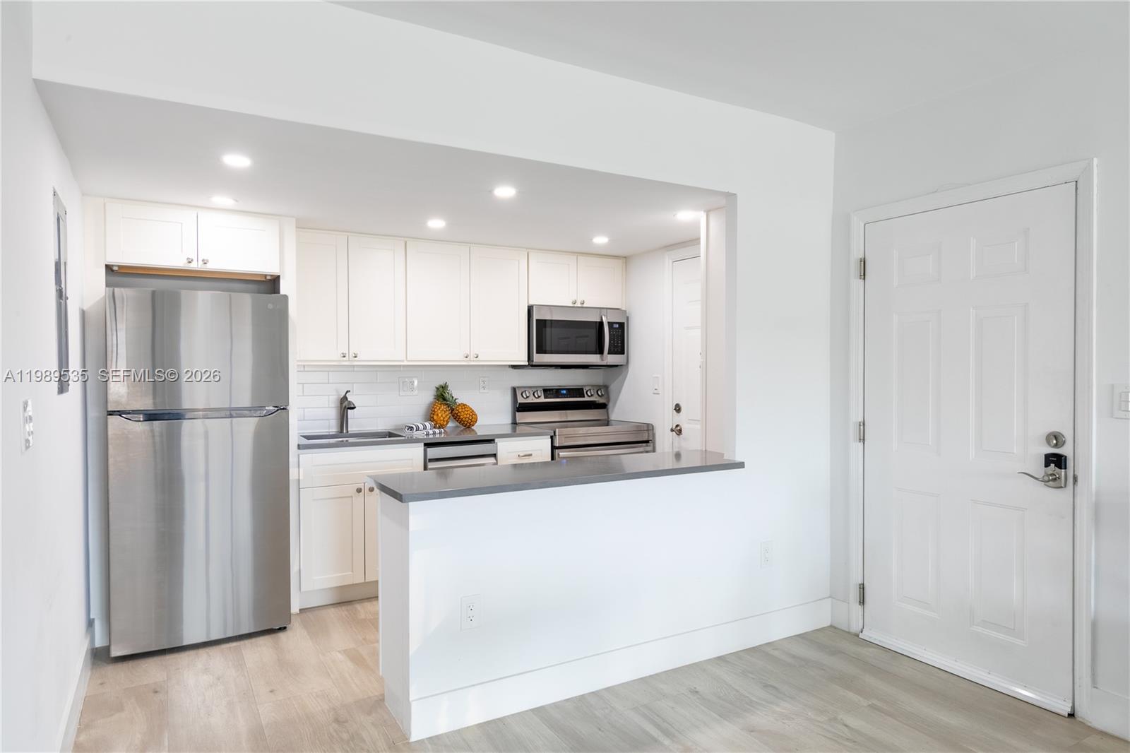 290 Sunrise Drive, Unit 3F Key Biscayne, FL 33149 - Photo 12 of 19 a kitchen with a refrigerator a stove top oven a sink and cabinets