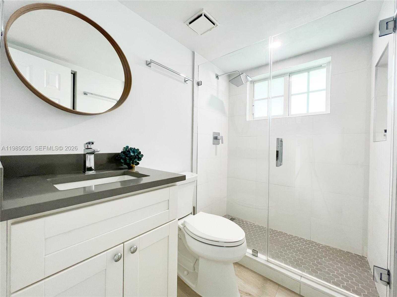 290 Sunrise Drive, Unit 3F Key Biscayne, FL 33149 - Photo 8 of 19 a bathroom with a toilet a sink a mirror and a shower