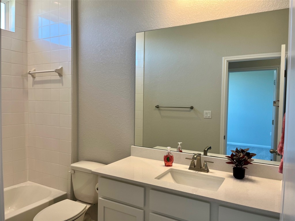 320 Creek Road, Unit 203 Dripping Springs, TX 78620 - Photo 10 of 14 a bathroom with a sink toilet and mirror