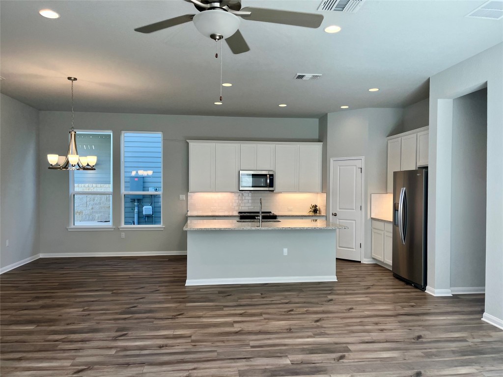320 Creek Road, Unit 203 Dripping Springs, TX 78620 - Photo 2 of 14 a view of kitchen with stainless steel appliances granite countertop a stove top oven a refrigerator and a fireplace with wooden floor