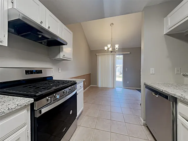 a kitchen with granite countertop a stove and a sink