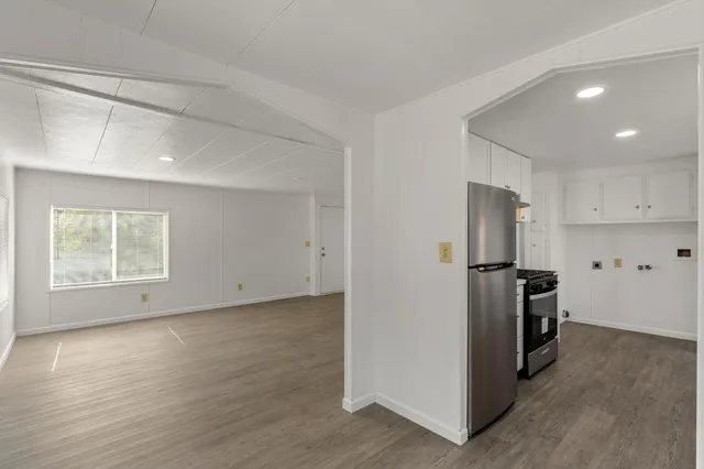 a view of a kitchen with a sink refrigerator and wooden floor