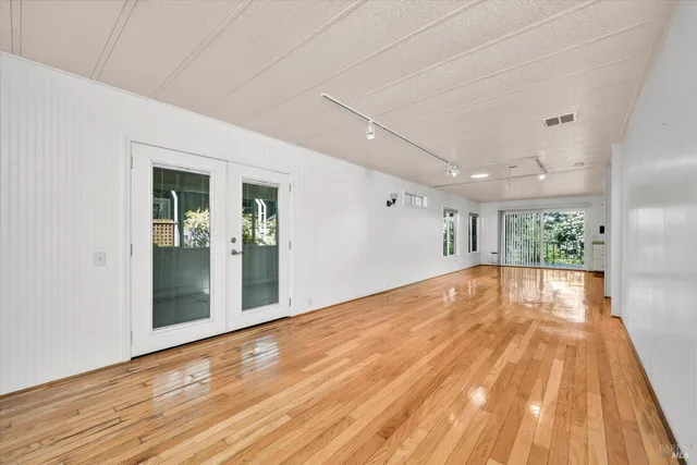a view of empty room with wooden floor