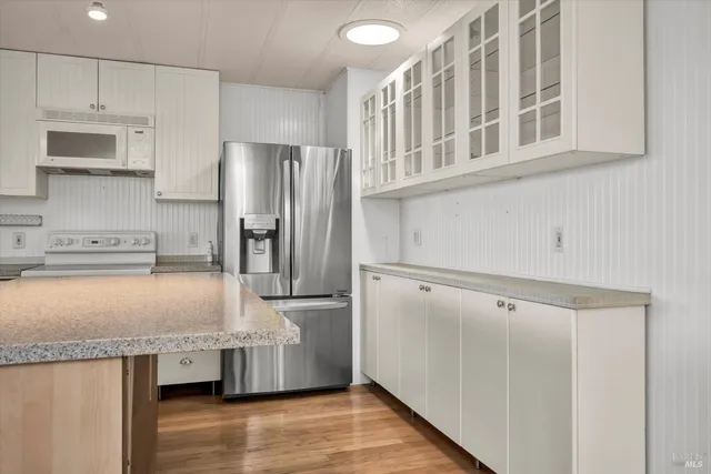 a kitchen with granite countertop a refrigerator and a sink