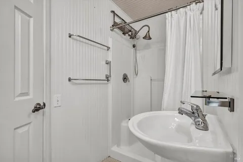 a bathroom with a sink a shower and a mirror