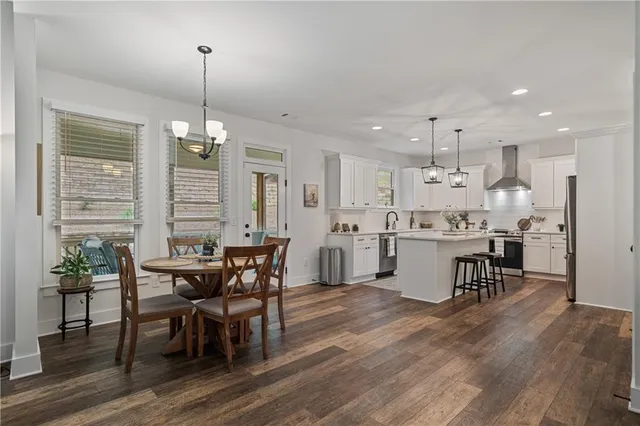 a bedroom with a bed dresser and a large window
