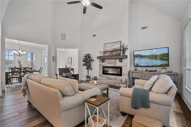 a dining room with wooden floor a chandelier a glass table and chairs