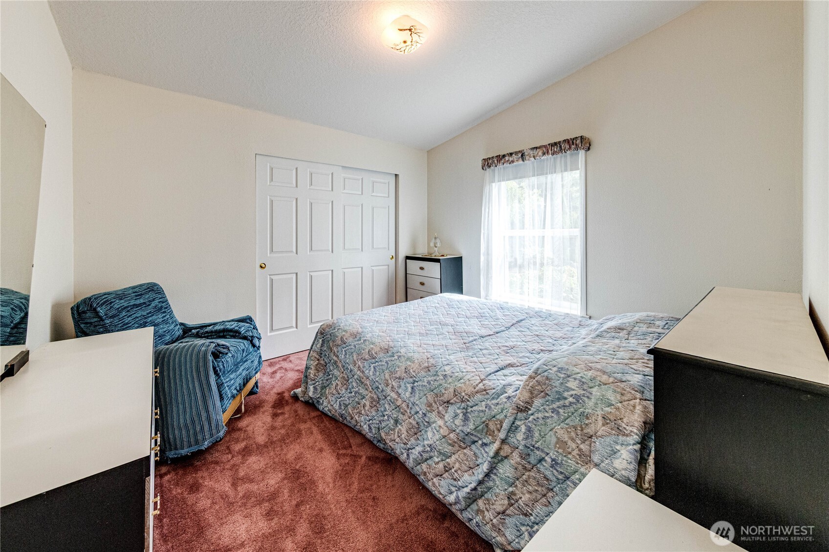 62 Johnson Road Port Angeles, WA 98363 - Photo 23 of 38 a bedroom with a bed and a chandelier