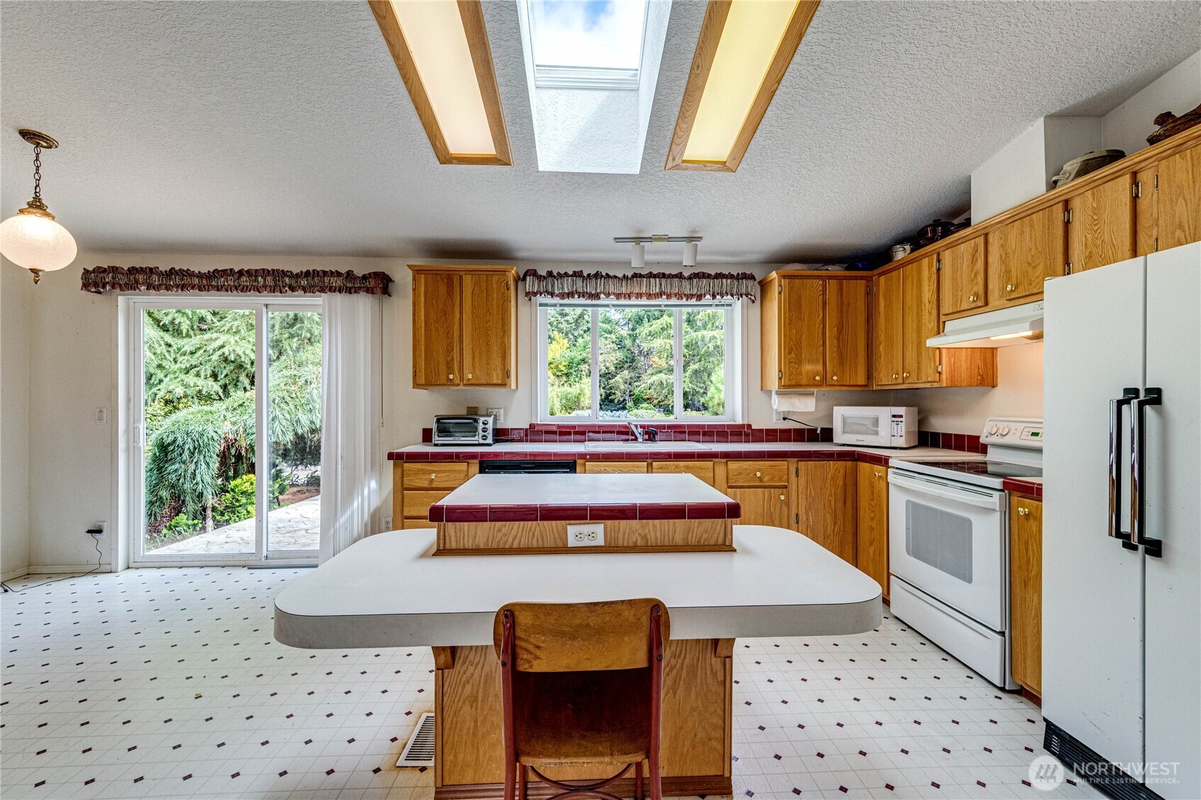 62 Johnson Road Port Angeles, WA 98363 - Photo 8 of 38 a kitchen with stainless steel appliances kitchen island granite countertop a refrigerator a sink a stove a dining table and chairs with wooden floor