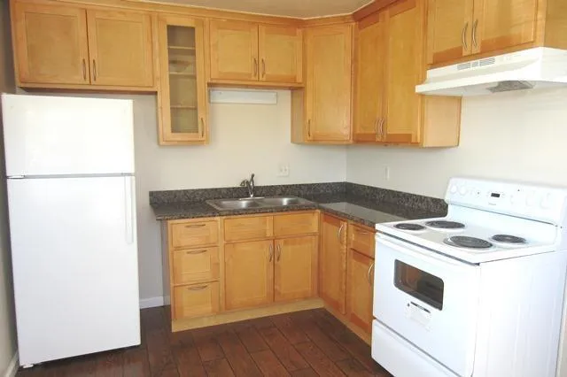 a kitchen with stainless steel appliances granite countertop a sink a stove a refrigerator with grey cabinets