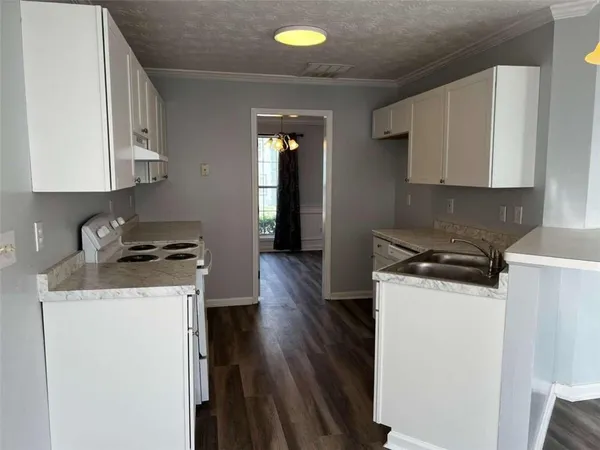 a kitchen with granite countertop a sink stove and refrigerator