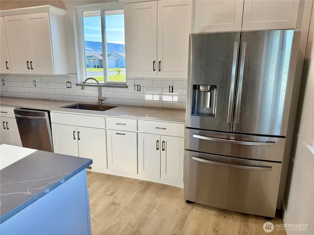 a kitchen with stainless steel appliances a refrigerator sink and cabinets
