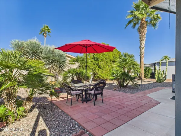 a view of a tables and chairs under an umbrella in patio