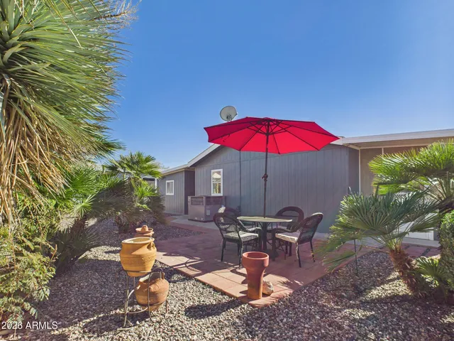 a view of a backyard with table and chairs under an umbrella