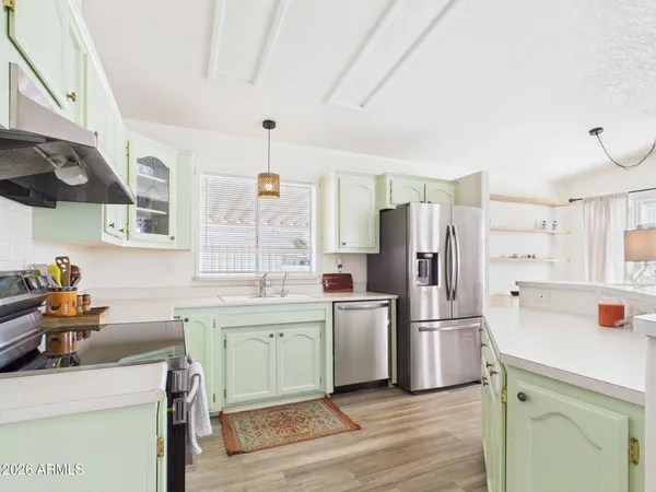 a kitchen with a sink a refrigerator and wooden floor