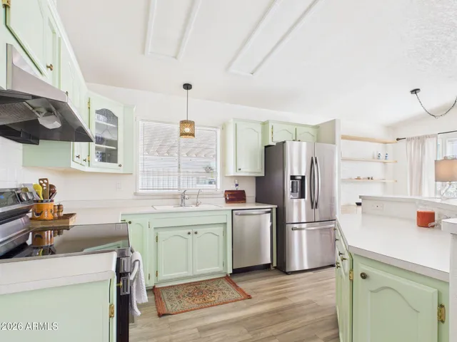 a kitchen with a sink a refrigerator and wooden floor