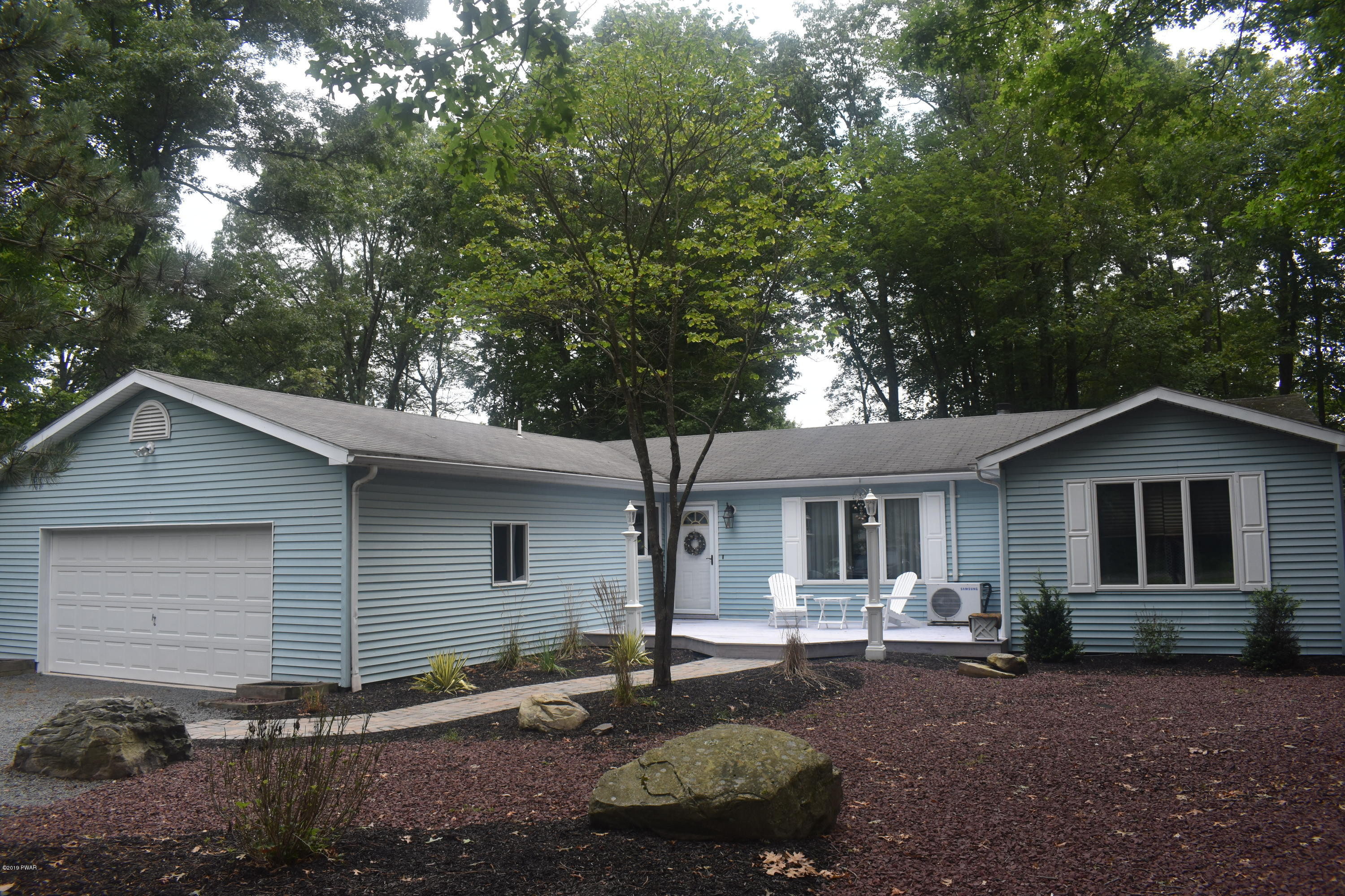 105 Rodeo Drive Hawley, PA 18428 - Photo 2 of 42 a front view of a house with a yard and garage