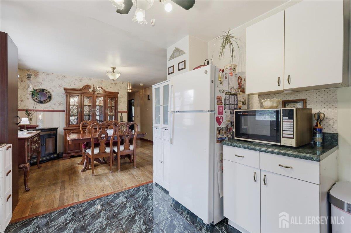 33 Ellison Road Somerset, NJ 08873 - Photo 11 of 38 a kitchen with stainless steel appliances granite countertop a refrigerator a stove top oven a sink a dining table and chairs with wooden floor