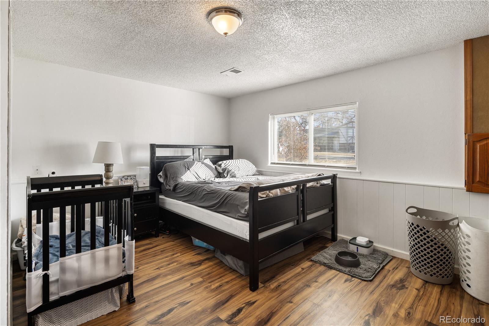 4615 Quail Street Wheat Ridge, CO 80033 - Photo 20 of 29 a bedroom with a bed and wooden floor