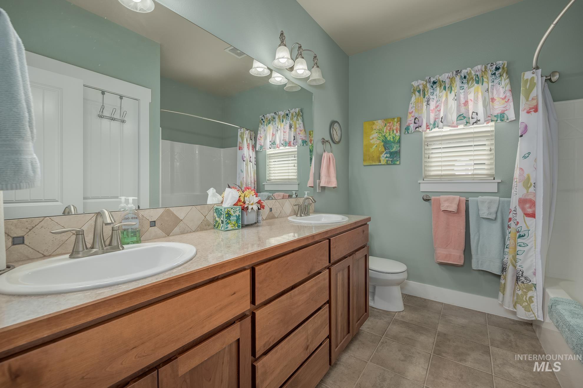 420 West Indianhead Road Weiser, ID 83672 - Photo 18 of 40 Double vanity featuring wood cabinetry, integrated sinks, and brushed nickel faucets