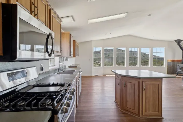 a open kitchen with white cabinets and wooden floor