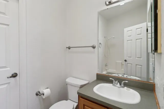 a bathroom with a toilet a sink and mirror