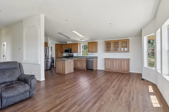 a view of a kitchen with furniture and wooden floor