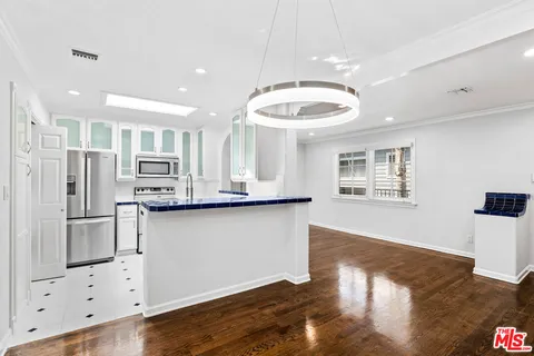 a kitchen with stainless steel appliances granite countertop a refrigerator and a stove top oven