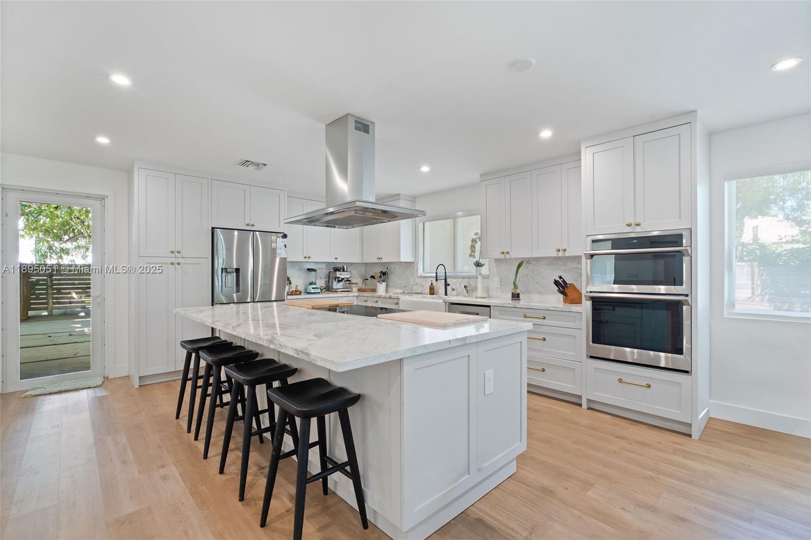 8121 Southwest 97th Terrace Miami, FL 33156 - Photo 15 of 38 a kitchen with stainless steel appliances a microwave a stove a sink dishwasher a refrigerator and white cabinets with wooden floor