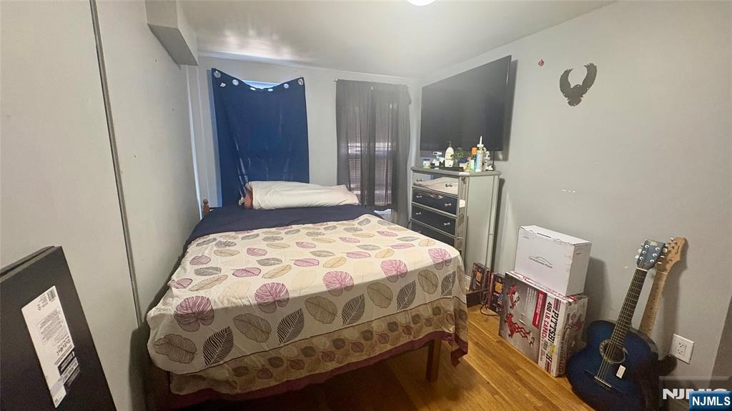 17 Cleveland Avenue, Unit 2 Harrison, NJ 07029 - Photo 7 of 12 a bedroom with a bed and a mirror