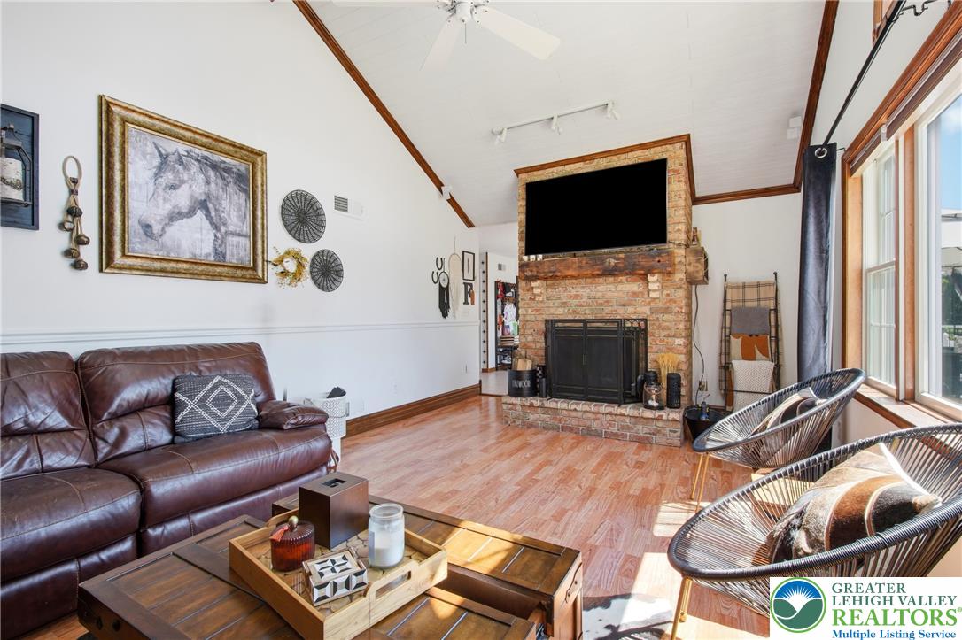 890 Lahr Road Nazareth, PA 18064 - Photo 19 of 71 A striking brick fireplace grounds this spacious living area with warm wood flooring and soaring vaulted ceilings.