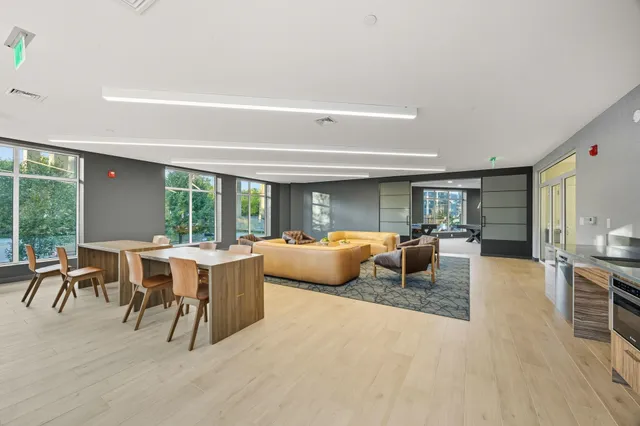 a living room with furniture a large window and wooden floor