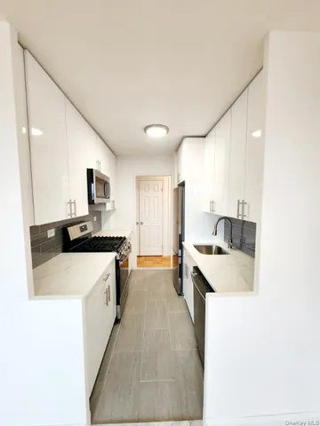 a kitchen with stainless steel appliances white cabinets and a sink