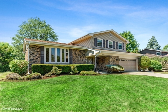 560 North Rohlwing Road Palatine, IL 60074 - Photo 1 of 25 a front view of a house with a yard and garage