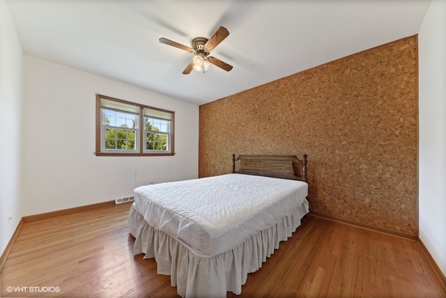 560 North Rohlwing Road Palatine, IL 60074 - Photo 18 of 25 a bedroom with a bed and wooden floor