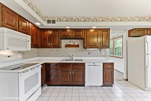 560 North Rohlwing Road Palatine, IL 60074 - Photo 9 of 25 a kitchen with a sink stove and cabinets