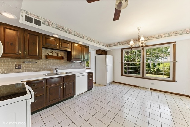 560 North Rohlwing Road Palatine, IL 60074 - Photo 10 of 25 a kitchen with stainless steel appliances granite countertop a sink and cabinets
