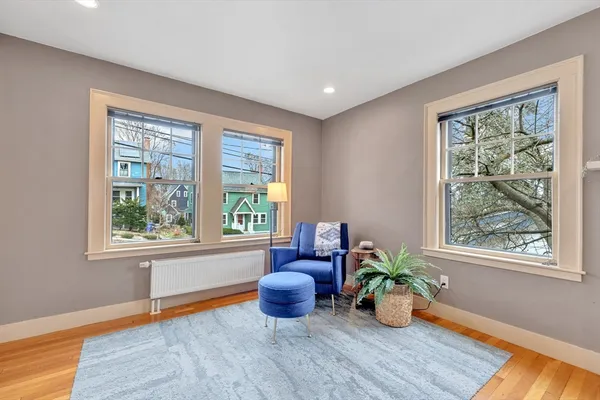 a living room with wooden floor and a potted plant