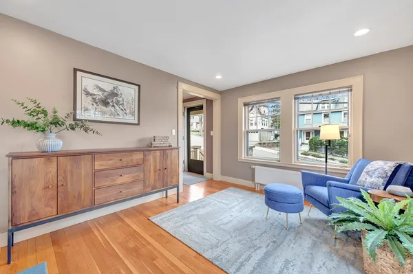 a living room with furniture two window and wooden floor