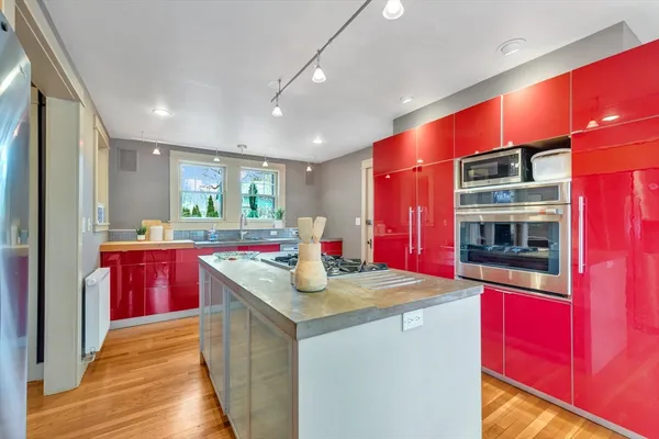 a kitchen with stainless steel appliances granite countertop a kitchen island a stove and a refrigerator