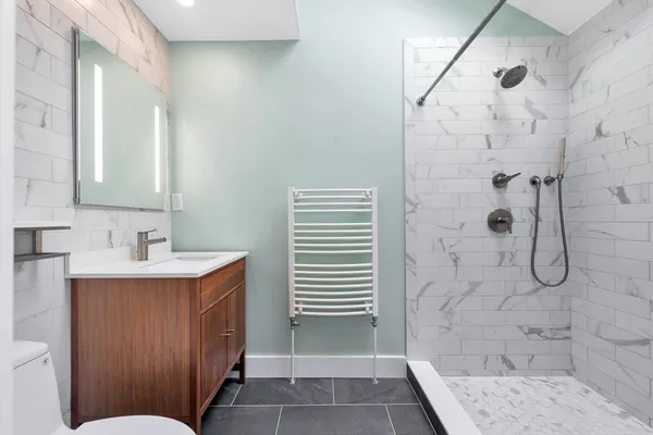 a bathroom with a sink a toilet and shower