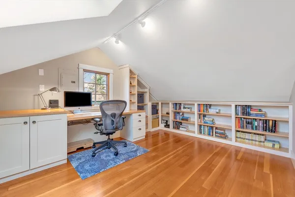 a living room with furniture a rug and a bookshelf