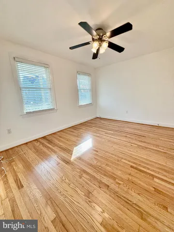 a view of a room with wooden floor and a ceiling fan