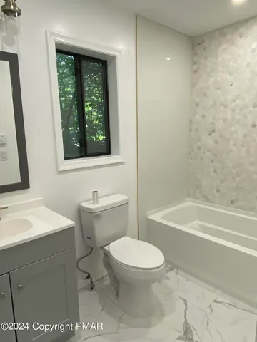 a bathroom with a toilet a sink and bathtub
