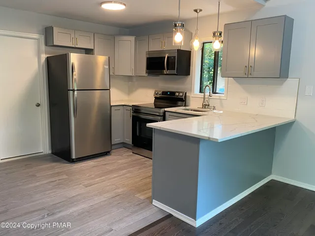 a kitchen with stainless steel appliances a refrigerator sink and microwave
